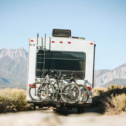 E-bikes loaded on a rack behind a motorhome in the mountains